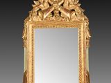 un miroir richement sculpté, orné d'un motif représentant un oiseau et des fleurs