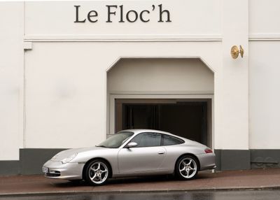 a silver car parked in front of a white building