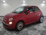 La petite voiture rouge est garée dans le garage, sur le sol à damier.