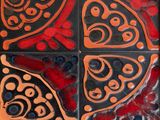a red and black tile on a wooden table