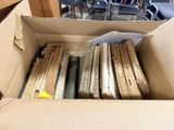 a cardboard box full of old books in a room