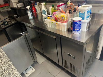 a stainless steel counter with a bunch of cleaning supplies on it