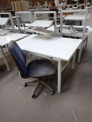 many desks and chairs in a room with a lot of shelves