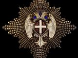 une croix en or surmontée d'une couronne et de deux ailes