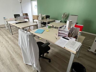 de nombreux bureaux et chaises dans une pièce dont l'un des murs est vert