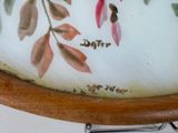 a close up of a vase with flowers painted on it