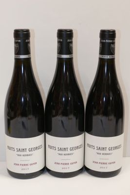 trois bouteilles de vin posées sur une table, l'une à côté de l'autre