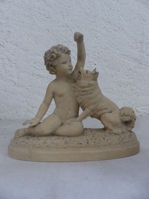 une statue représentant un garçon et un chien posée sur une table