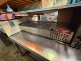 plan de travail en acier inoxydable dans la cuisine d'un restaurant, équipée d'une cuisinière et d'un four