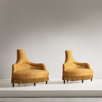 une paire de chaises jaunes ornées de franges dans une pièce blanche