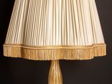 une image représentant une lampe posée sur une table en bois, sur fond noir