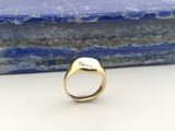 une image représentant une bague en or avec une pierre en arrière-plan