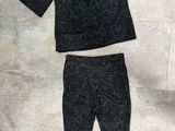un pull noir et un legging posés par terre à côté d'une paire de chaussures