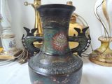 a black vase with a dragon handle on a table