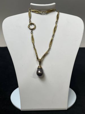 un mannequin blanc portant un collier orné d'une perle noire