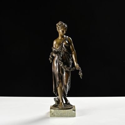 a bronze statue of a woman holding a flower on a marble base
