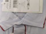 the shirt is white with a red stripe on the collar