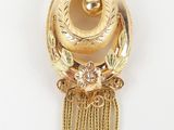 a close up of a gold plated pendant on a white background