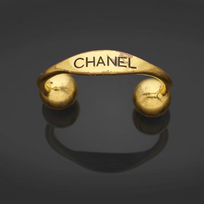 un bracelet en or sur lequel est gravé le mot « Chanel »