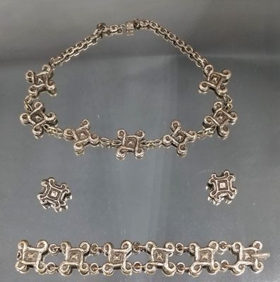 un gros plan d'un collier et d'un bracelet en argent posés sur une table