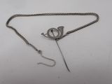 an image of a silver chain with a pin attached to it