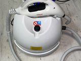 a white and blue steam iron sitting on a wooden floor