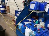a man that is standing in front of some blue barrels