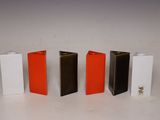 four different colors of lighters are lined up on a white surface