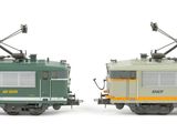 two trains that are sitting side by side on a white surface