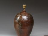 un grand vase marron surmonté d'une lampe