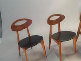three wooden chairs sitting next to each other on a white surface