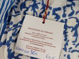 blue and white patterned shirt with a tag on it