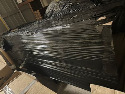 un gros tas de plastique noir emballé dans un entrepôt