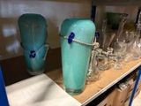bottles and glasses on a shelf in a store filled with glassware