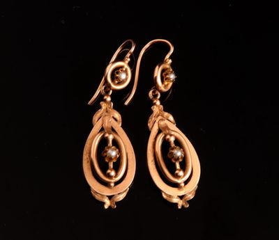 une paire de boucles d'oreilles en or sur fond noir