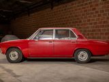 a red car parked in a garage next to a brick wall