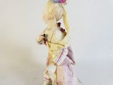 a figurine of a woman in a dress and hat