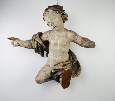 a small statue of a child hanging on a wall
