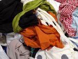 a pile of clothes sitting on the floor next to a window