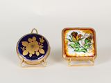deux petites assiettes ornées de fleurs, posées l'une à côté de l'autre