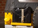 a black suitcase sitting on the back of a yellow jeep