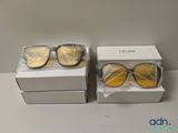 Deux paires de lunettes de soleil sont posées dans une boîte sur une table.