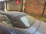 two cars parked in a parking lot next to a brick wall
