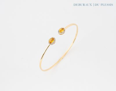 un gros plan d'un bracelet en saphir jaune et diamants sur fond blanc
