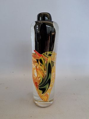 a glass vase with a painting on it on a table