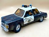 une petite voiture de police en jouet posée sur une table
