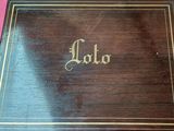 une vieille boîte en bois sur laquelle est inscrit le mot « Lola »