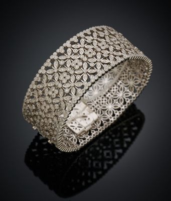 gros plan d'un bracelet en argent sur une surface noire