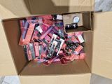a cardboard box filled with assorted makeup products