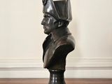 a bust of a man wearing a helmet on a wooden floor